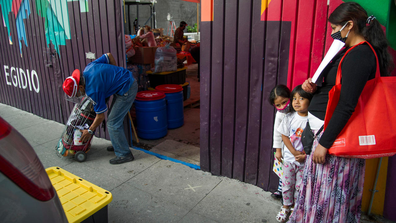 امرأة وابنتها تنتظران في طابور للحصول على وجبة طعام في مكسيكو في العاشر من يونيو 2020