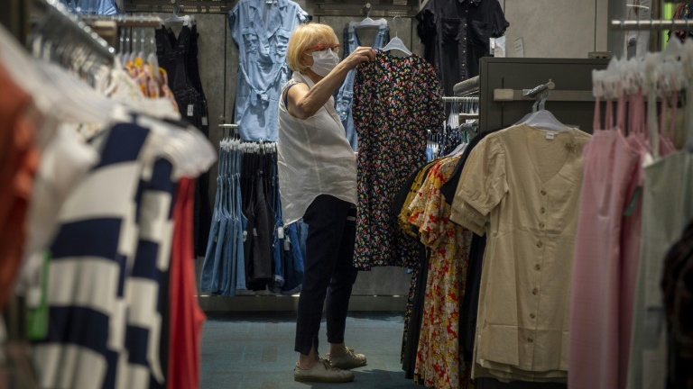 امرأة تتسوق في مونتريال (كندا) وهي تضع الكمامة. وفي ظلّ العزل العام، شهدت التجارة الإلكترونية نموّا شديدا هذا العام.