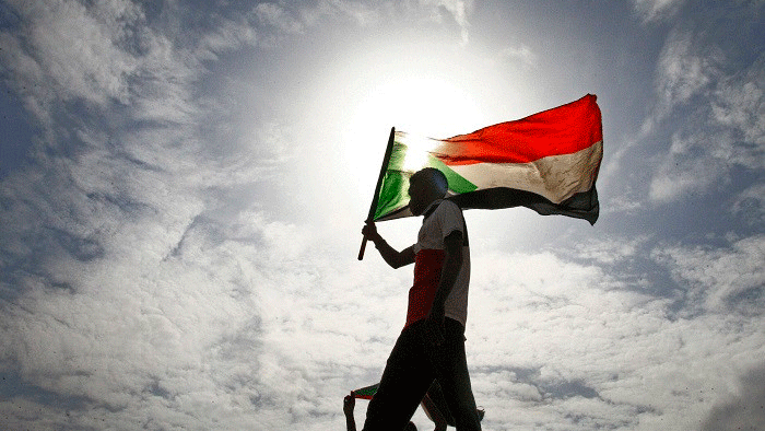 متظاهر يرفع العلم السوداني شرق الخرطوم