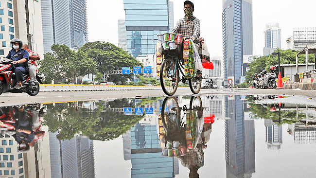 أحد المارة على دراجة هوائية في جاكرتا