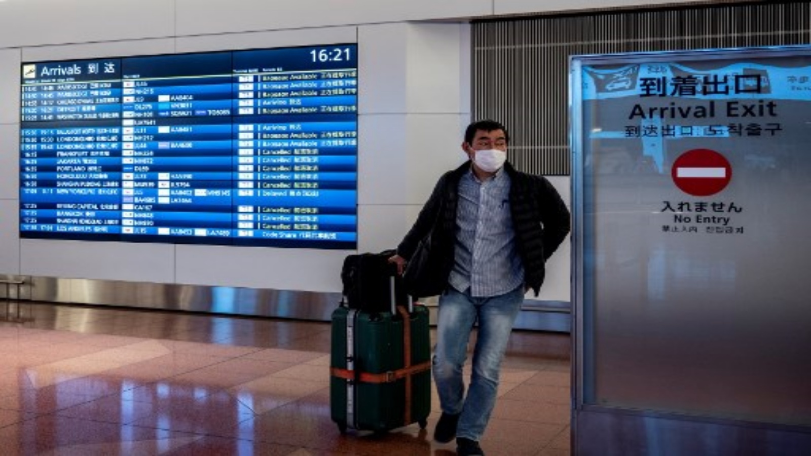مسافر يغادر منطقة الوصول في مطار هانيدا بطوكيو في 27 ديسمبر 2020 ، بعد أن أعلنت الحكومة المزيد من القيود على السفر بسبب ارتفاع حالات الإصابة بفيروس كورونا المستجد في جميع أنحاء البلاد