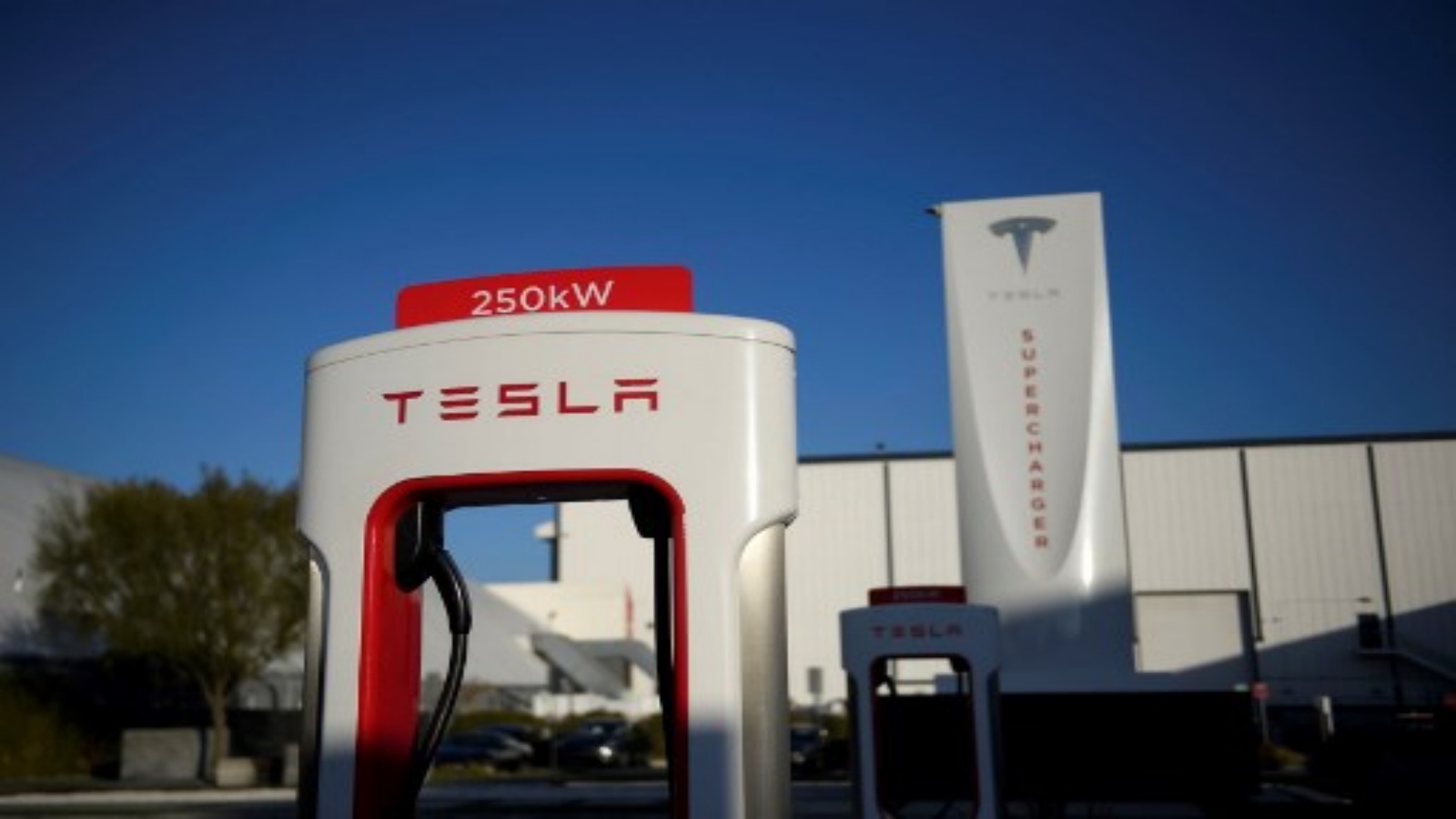 شعار Tesla على محطة شحن سيارة كهربائية بقدرة 250 كيلو وات في محطة شاحن Tesla Inc. في 4 يناير 2021 في هوثورن ، كاليفورنيا. بعد ارتفاع الأسهم في عام 2020 مع ارتفاع عمليات تسليم السيارات ، تدخل تسلا عام 2021 مع الكثير من الزخم حتى مع بقاء رؤيتها في جعل السيارات الكهربائية سائدة بعيدً