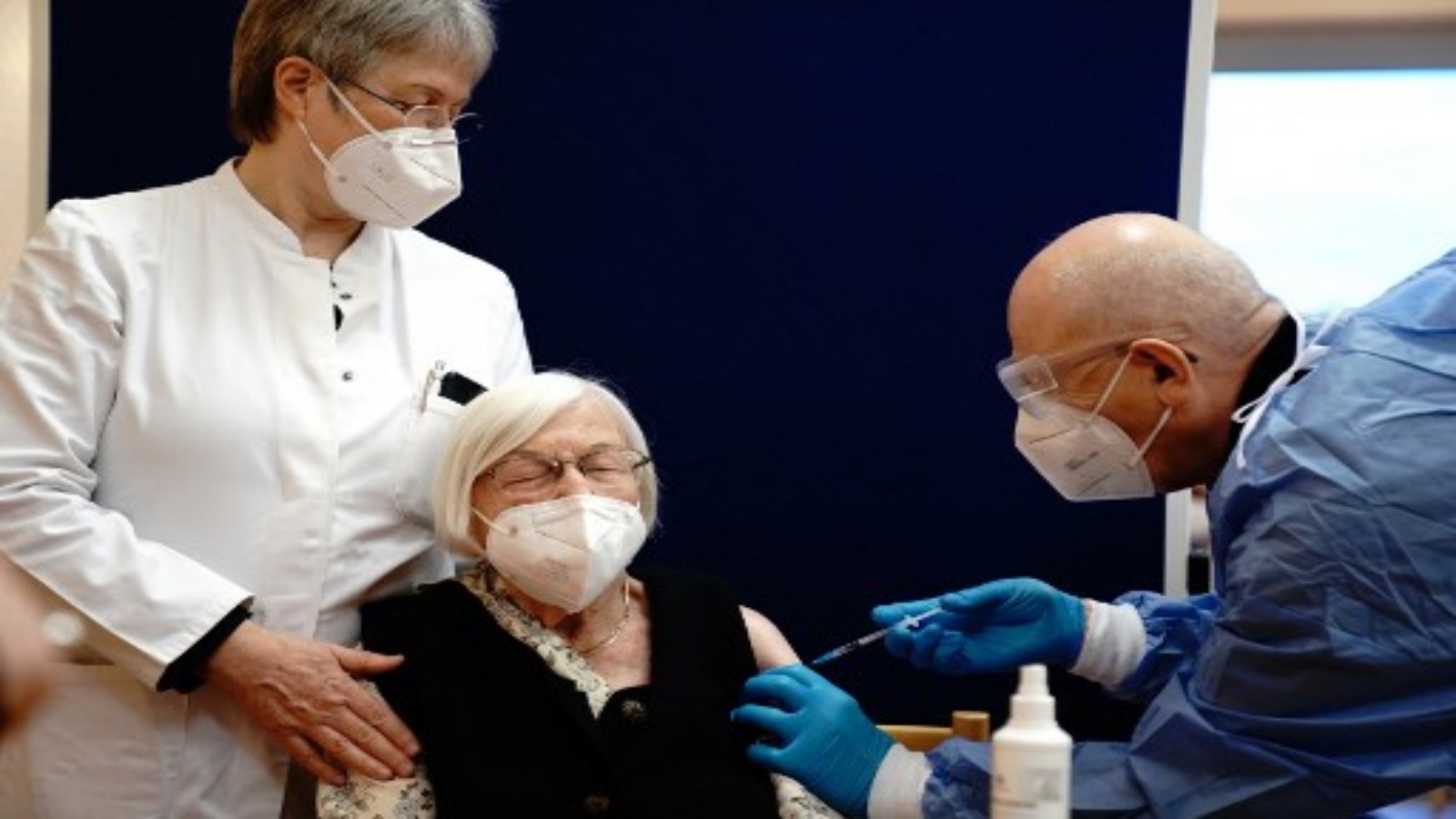 جيرترود هاس (C) البالغة من العمر 101 عامًا تعطى جرعة من لقاح فيروس كورونا Pfizer-Biontech Covid-19 من قبل الطبيب فاتمير دالاداكو (يمين) في دار رعاية Agaplesion Bethanien Sophienhaus في برلين في 27 ديسمبر 2020.