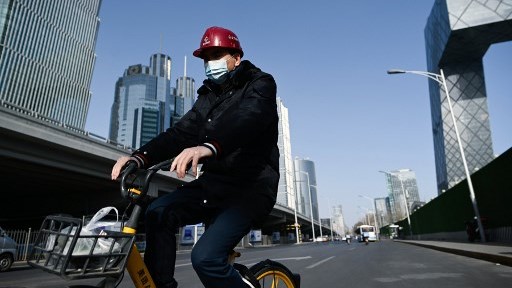 صيني يمر بدراجته في الوسط التجاري بمدينة بكين الجمعة