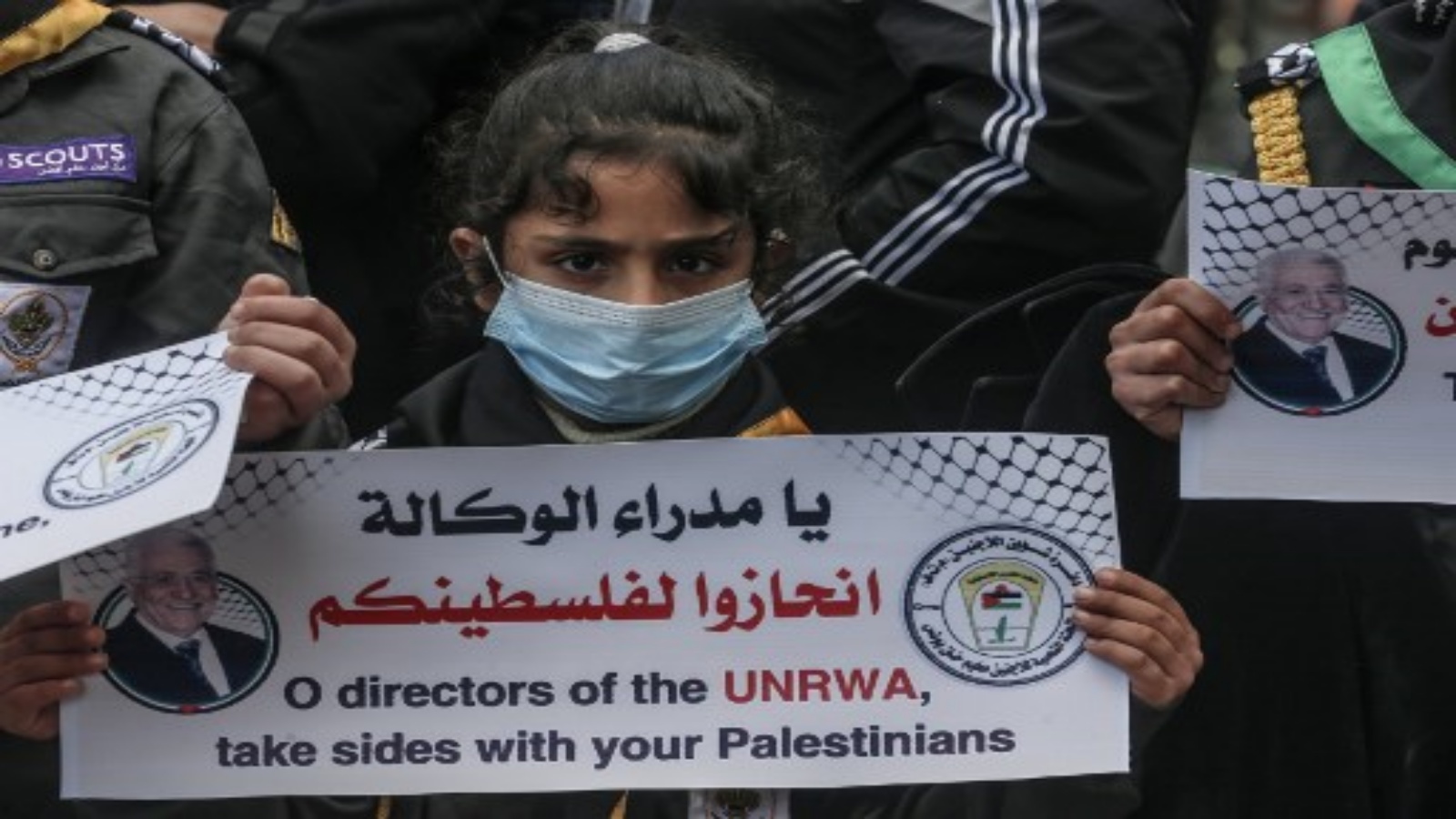 فلسطينيون يتجمعون خلال احتجاج على قطع المساعدات الغذائية من قبل وكالة الأمم المتحدة لإغاثة وتشغيل اللاجئين الفلسطينيين (الأونروا) ، في مخيم خان يونس للاجئين ، 20 يناير ، 2021.