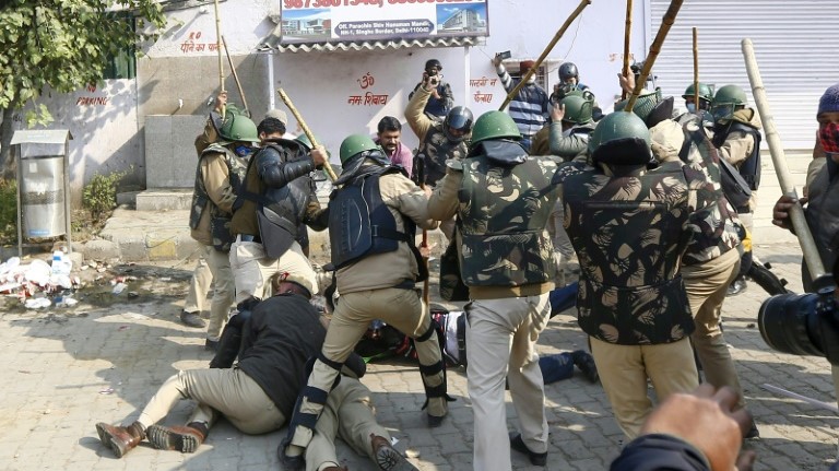 عناصر في الشرطة الهندية تضرب مزارعا خلال احتجاج ضد قوانين الإصلاح الزراعي سد طريقا سريعا في منطقة سينغو عند مدخل العاصمة نيودلهي الجمعة