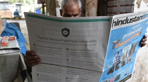 هندي يقرأ جريدة على صفحتها الأخيرة إعلان لشركة واتساب