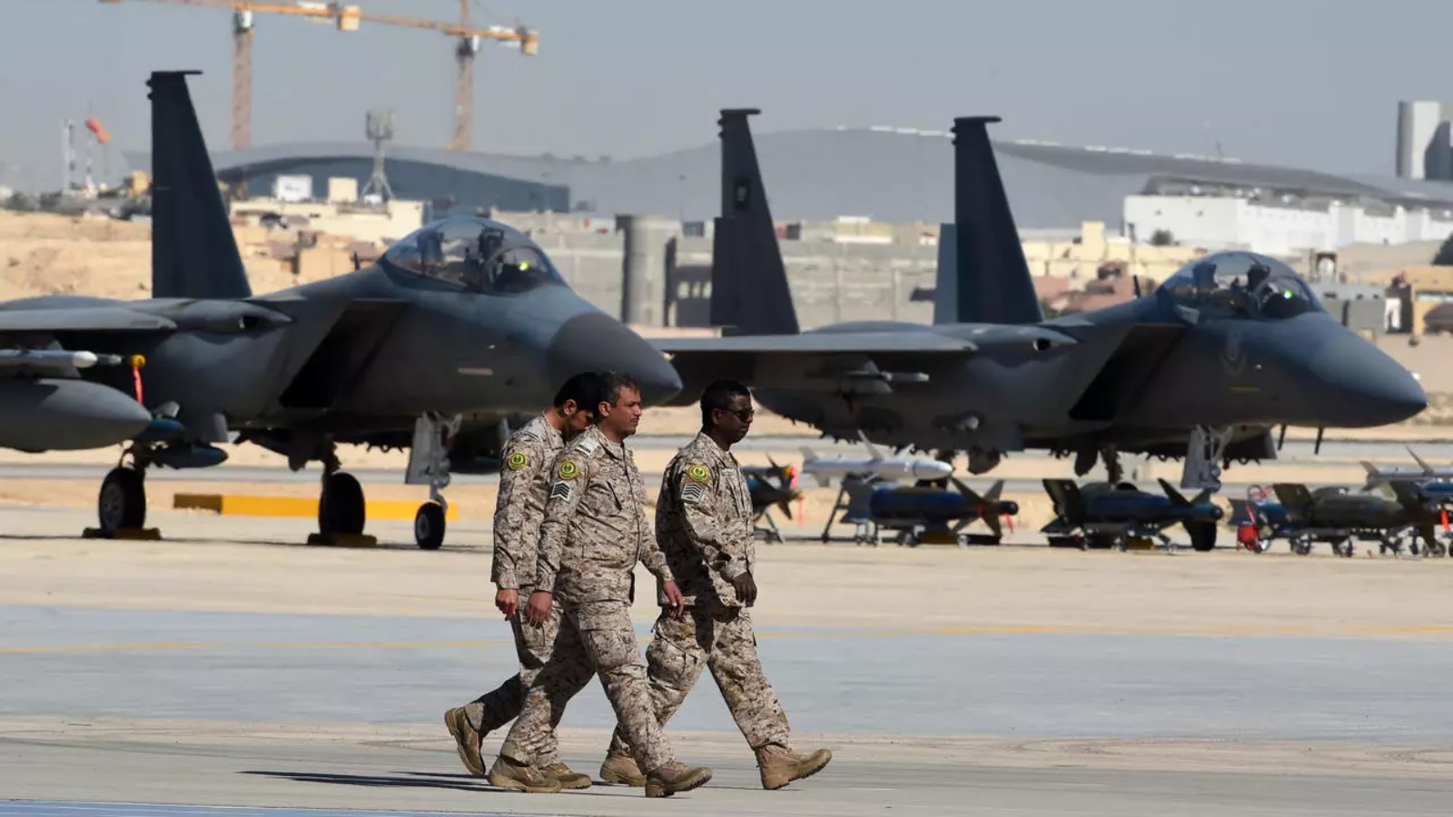 ضباط عسكريون سعوديون يمرون أمام طائرات مقاتلة من طراز F-15 وقنابل GBU وصواريخ معروضة خلال حفل بمناسبة الذكرى الخمسين لإنشاء أكاديمية الملك فيصل الجوية في قاعدة الملك سلمان الجوية في الرياض عام 2017