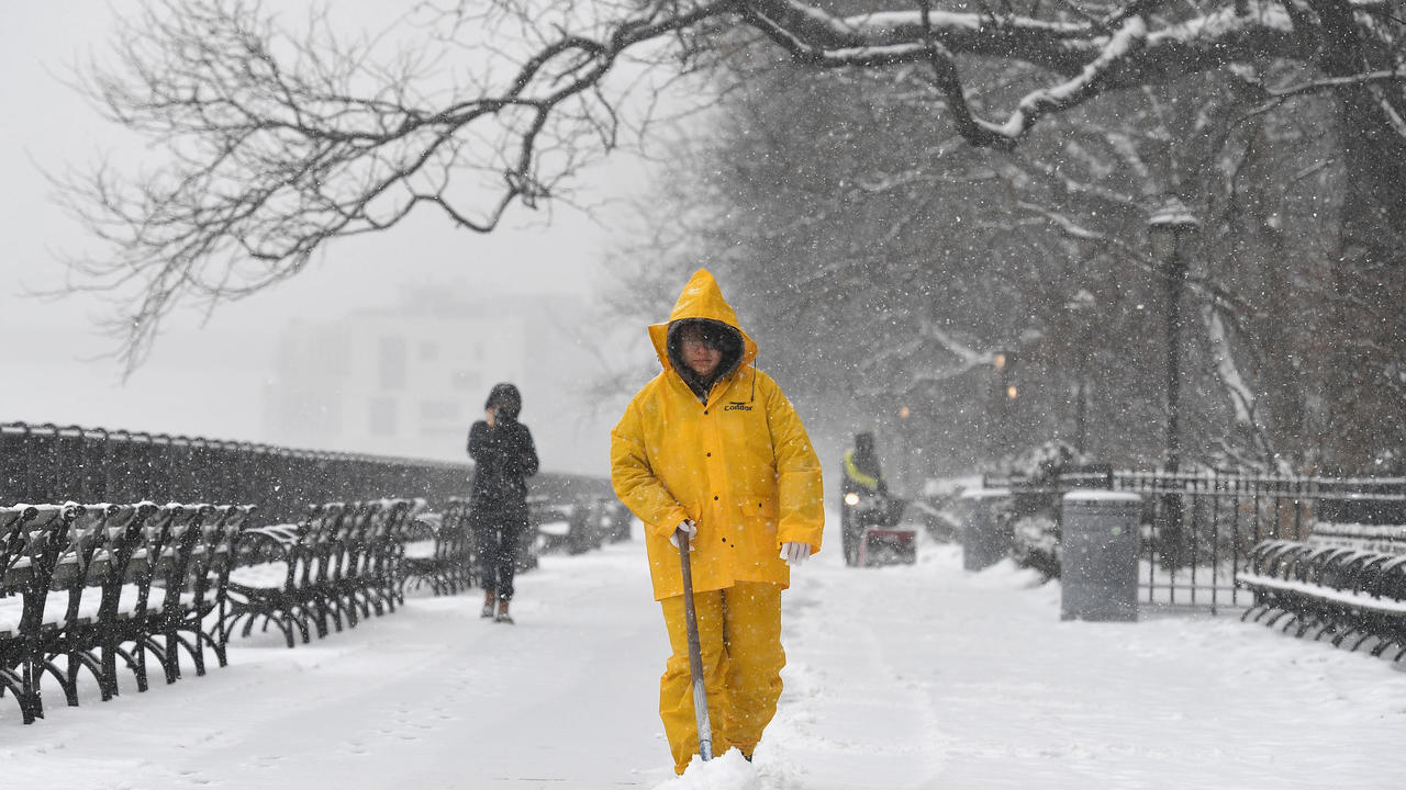 رجل يجرف الثلج في نيويورك، في 18 شباط/فبراير 2021 