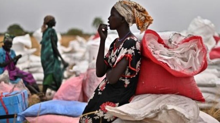 قرويون إلى جانب أكياس مساعدات غذائية أرسلها برنامج الأغذية العالمي على متن طائرة في أيود في جنوب السودان بتاريخ 6 فبراير 2020