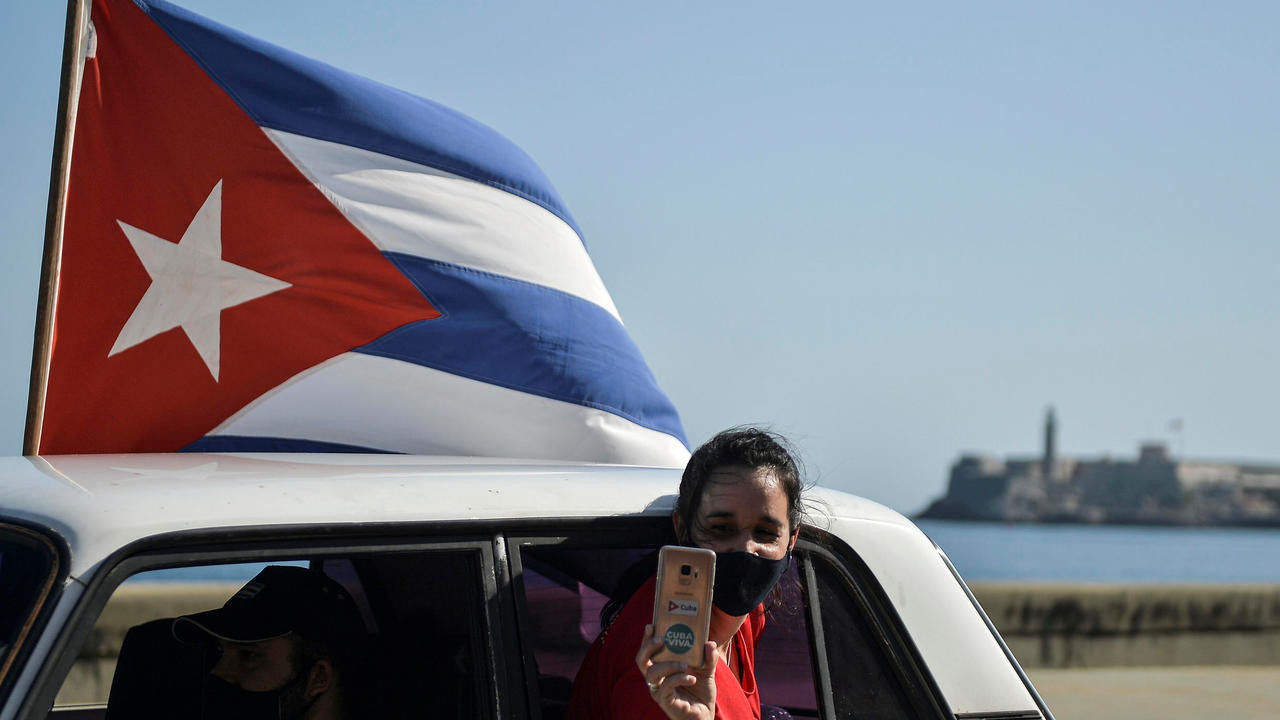 شابة تلتقط صورة من سيارتها خلال تجمع حاشد يدعو إلى إنهاء الحصار الأميركي، في هافانا 28 آذار/مارس 2021 