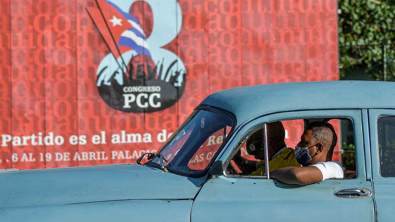 سيارة أميركية قديمة الطراز امام ملصق للمؤتمر الثامن للحزب الشيوعي في كوبا في 6 نيسان/ابريل 2021