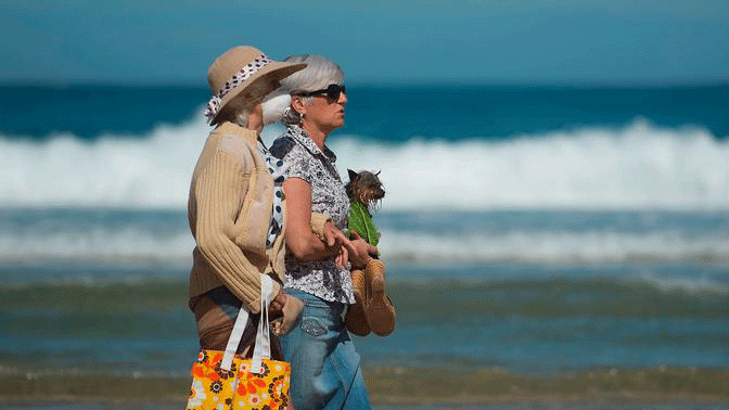 تضرر القطاع السياحي بقوة في معظم مدن أوروبا، وفي الصورة سيدتان تقومان بجولة على الشاطئ في سان سيباستيان