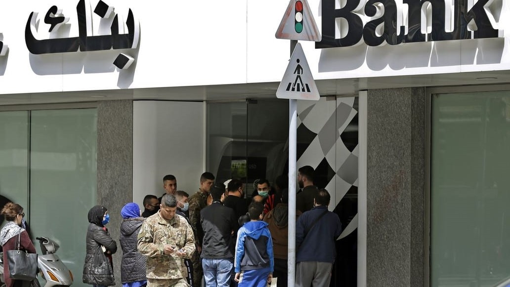 لبنانيون خارج أحد المصارف يجاولون سحب بعض المال من ودائعهم
