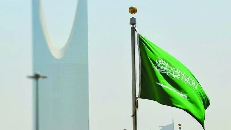 العلم السعودي أمام برج المملكة في العاصمة السعودية الرياض