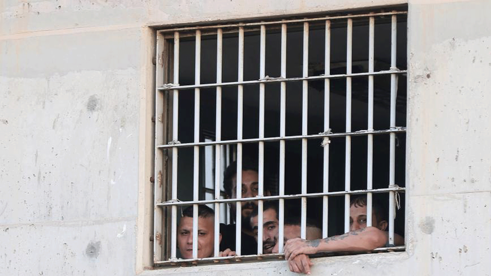 معتقلون ينظرون من نافذة مركز إعادة التأهيل في الزرقاء، شرق عمان، في 11 تموز/يوليو 2018