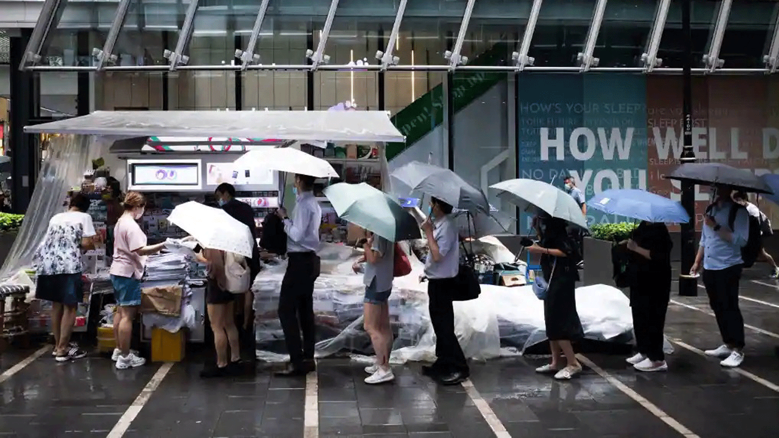 الناس في طابور لشراء نسخ من الإصدار الأخير من صحيفة آبل ديلي في منطقة هونغ كونغ المركزية في 24 حزيران/ يونيو 2021