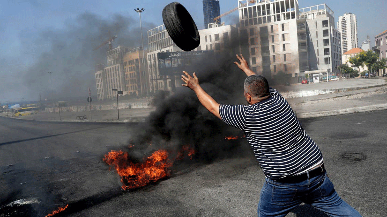 متظاهر يحرق الإطارات لإغلاق ساحة الشهداء في العاصمة اللبنانية بيروت في 26 حزيران / يونيو 2021، احتجاجاً على الأزمة المعيشية وتقاعس السلطة