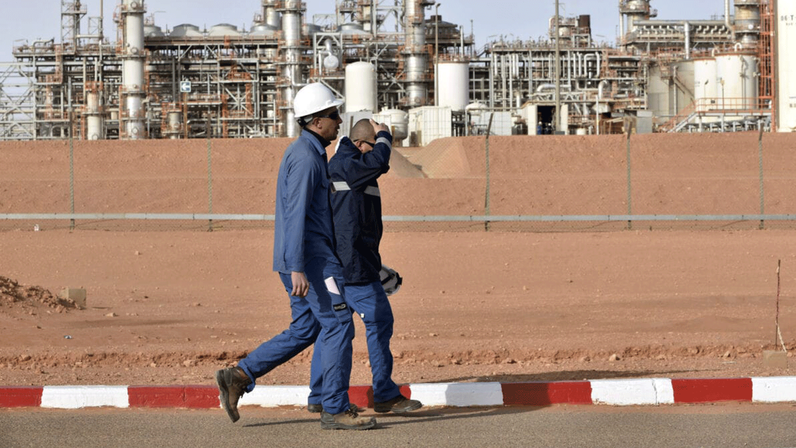 عاملان يسيران في محطة الغاز في عين أمناس الجزائرية في 16 كانون الثاني/ يناير2018