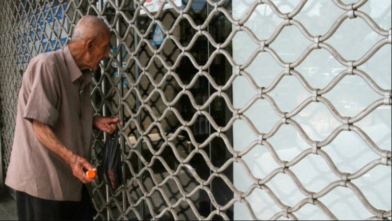 رجل مسن خارج صيدلية مغلقة في مدينة صيدا جنوب لبنان في 9 يوليو 2021