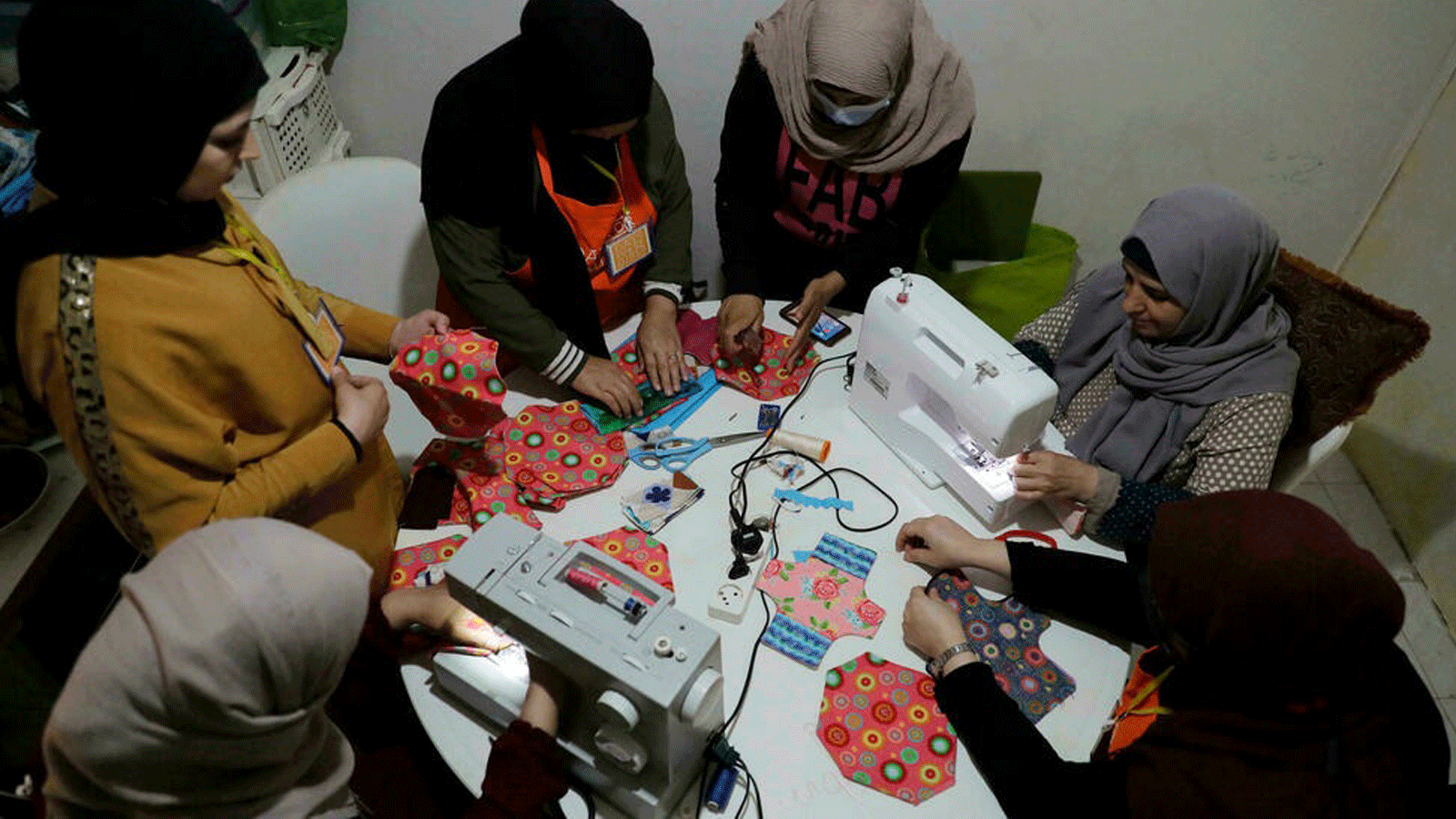 أعضاء منظمة Days For Girls الدولية غير الحكومية والشريك المحلي WingWoman Lebanon يدربن اللاجئات على صنع فوط صحية قابلة لإعادة الاستخدام من القماش الملون في مخيم شاتيلا للاجئين الفلسطينيين في بيروت