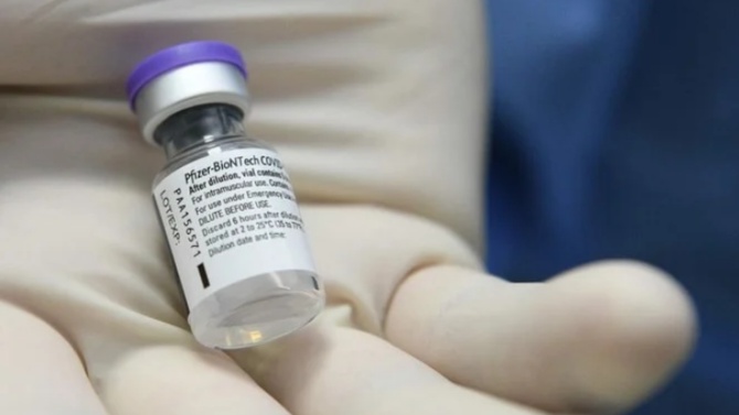 عامل صحي يحمل جرعة لقاح فايزر الذي أعلن الأردن عن بدء تطعيم من هم فوق الـ12 عاماً به اعتبارا من الاحد