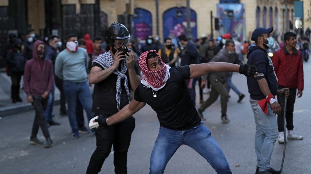 متظاهر يقذف الحجارة باتجاه مجلس النواب اللبناني في 13مارس 2021