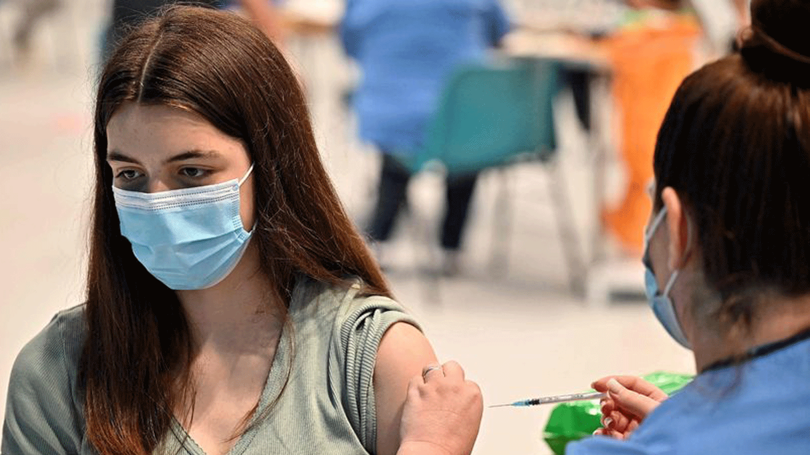 المراهقة كاتي مور تتلقى حقنة Covid-19 في مركز التطعيم في بارهيد، جنوب غلاسكو