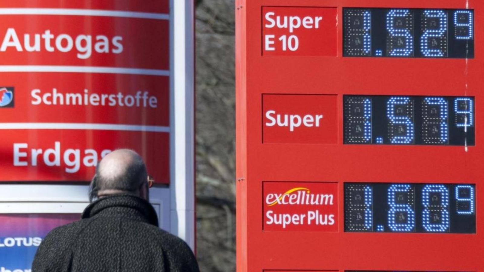 رجل يراقب لوحة أسعار البنزين التي أصبحت نقطة اشتعال سياسية في أوروبا.