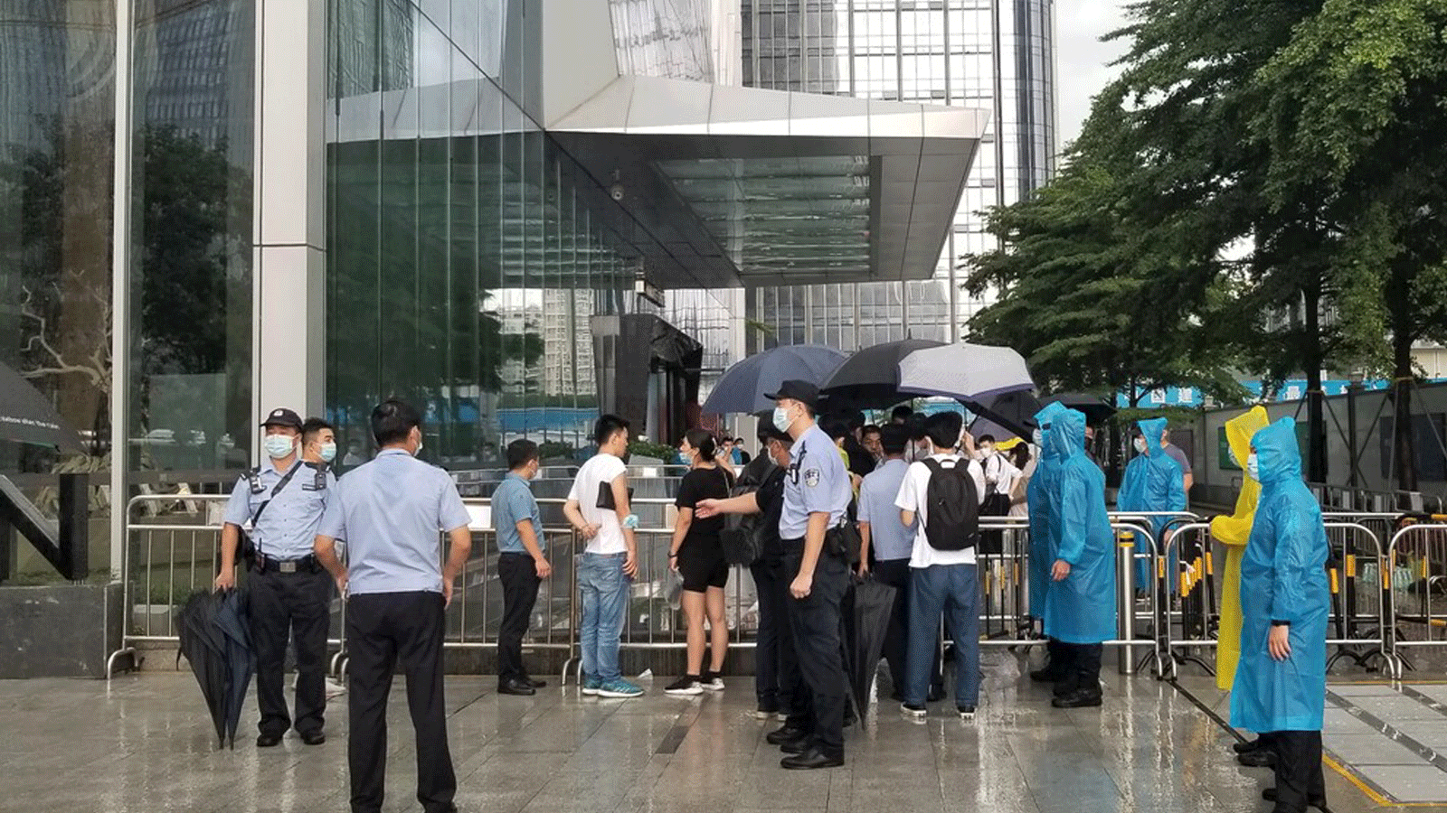 الشرطة وحراس الأمن يقفون أمام المدخل المحصن لمقر مجموعة إيفرغراند الصينية في شنتشن.