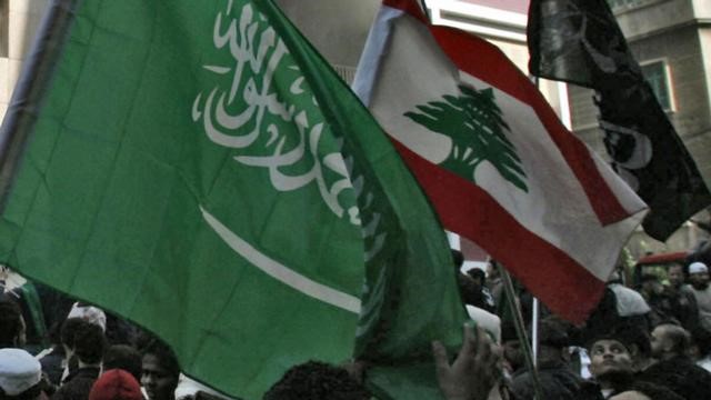 متظاهرون لبنانيون يرفعون علمًا للسعودية إلى جانب العلم اللبناني تعبيرًا عن رفضهم الإضرار بالعلاقات بين بلدهم والمملكة 