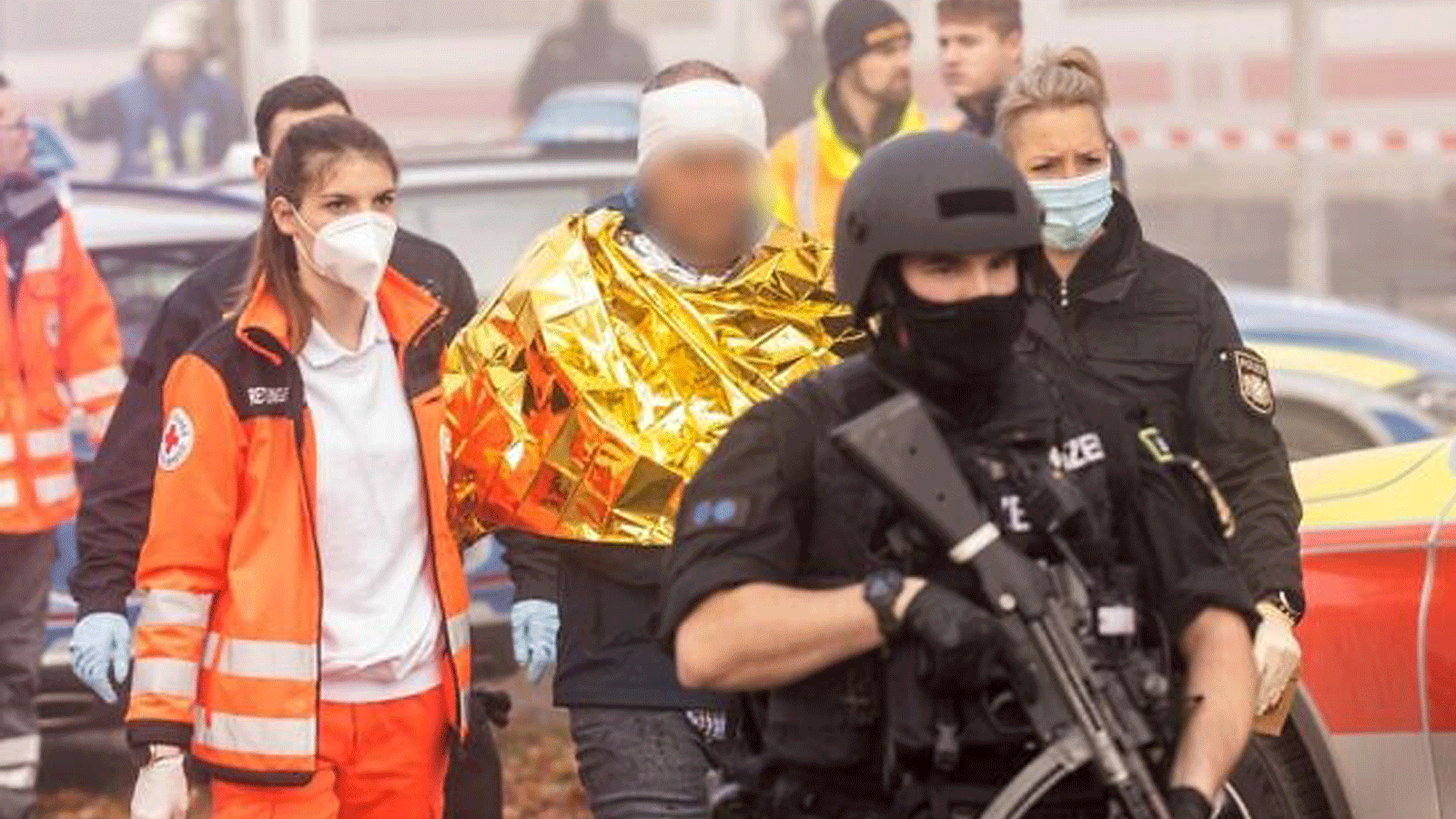 الشرطة الألمانية وعمال الإنقاذ يسيرون مع رجل محتجز في 6 تشرين الثاني/نوفمبر 2021، في زوبرسدورف، جنوب ألمانيا، بعد إصابة عدة أشخاص في هجوم بسكين على قطار فائق السرعة.