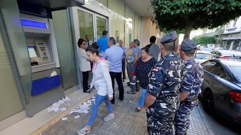 مواطنون لبنانيون ينتظرون أمام أحد المصارف في بيروت