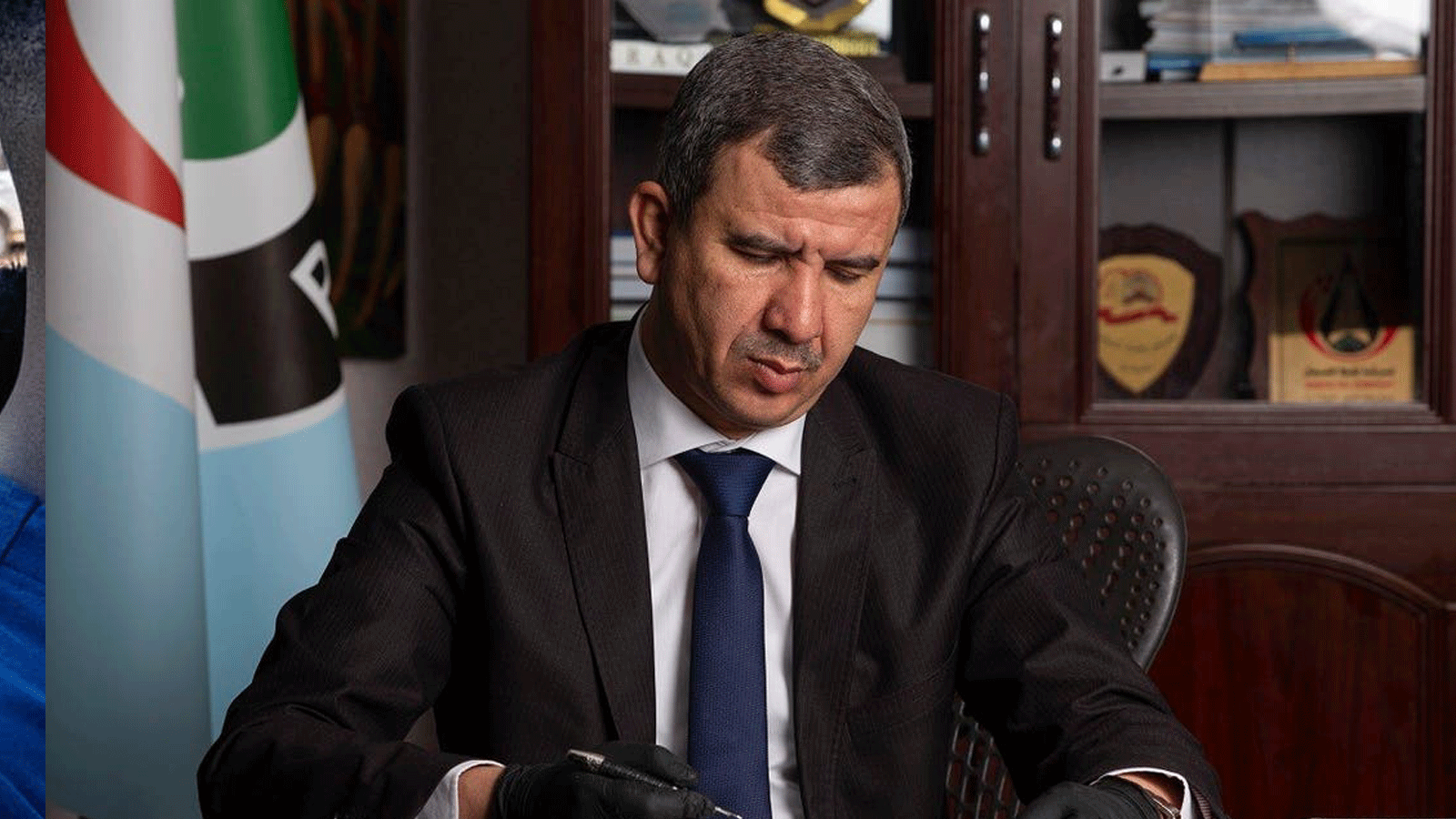 وزير النفط العراقي إحسان عبد الجبار يقرأ وثائق في شركة نفط البصرة في المدينة الساحلية جنوبي العراق. 9 أيار/مايو 2020.