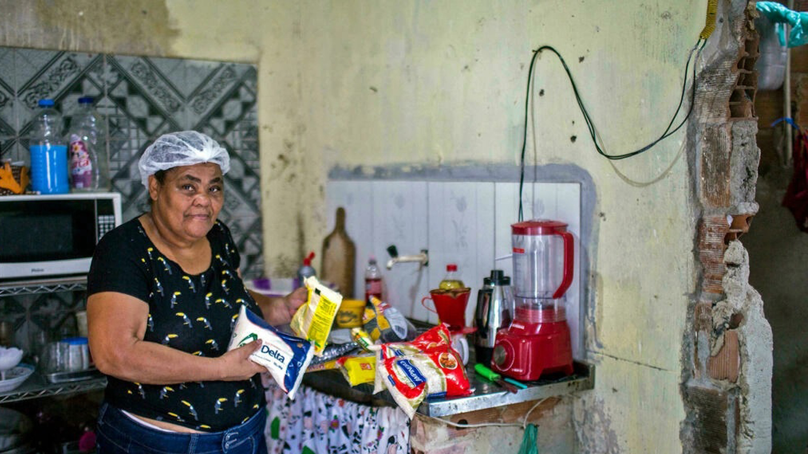 إيتا ماريا دي سوزا ، 59 عامًا ، تقف مع طردها الغذائي الأساسي الذي تبرعت به منظمة 'Acao da Cidadania' (حركة المواطنة) غير الحكومية ، خلال حدث 'Natal sem Fome' (عيد الميلاد بدون جوع) في ريو دي جانيرو