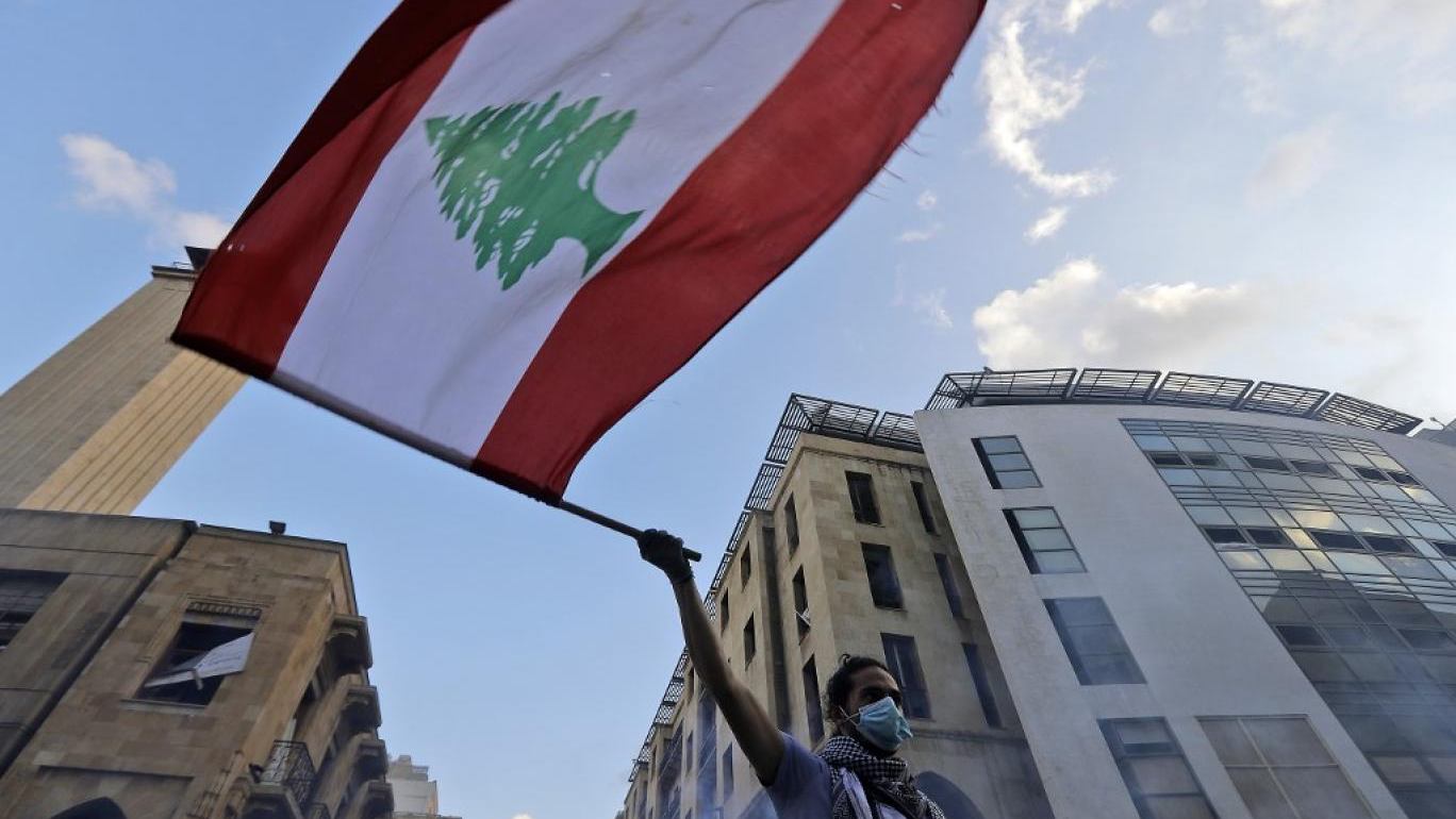 متظاهر يرفع علم لبنان خلال إحدى التظاهرات المطالبة بالإصلاح السياسي والاقتصادي والاجتماعي في لبنان