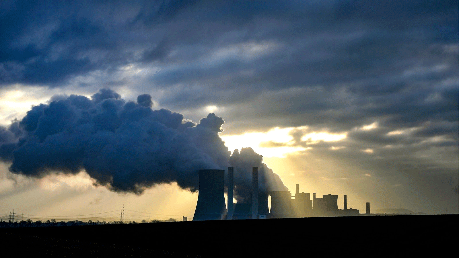 الدخان يتصاعد من أبراج التبريد في محطة الطاقة التي تعمل بالليغنيت لشركة الطاقة الألمانية العملاقة RWE في نيدراوسيم، غرب ألمانيا. 17 كانون الثاني\ يناير 2022