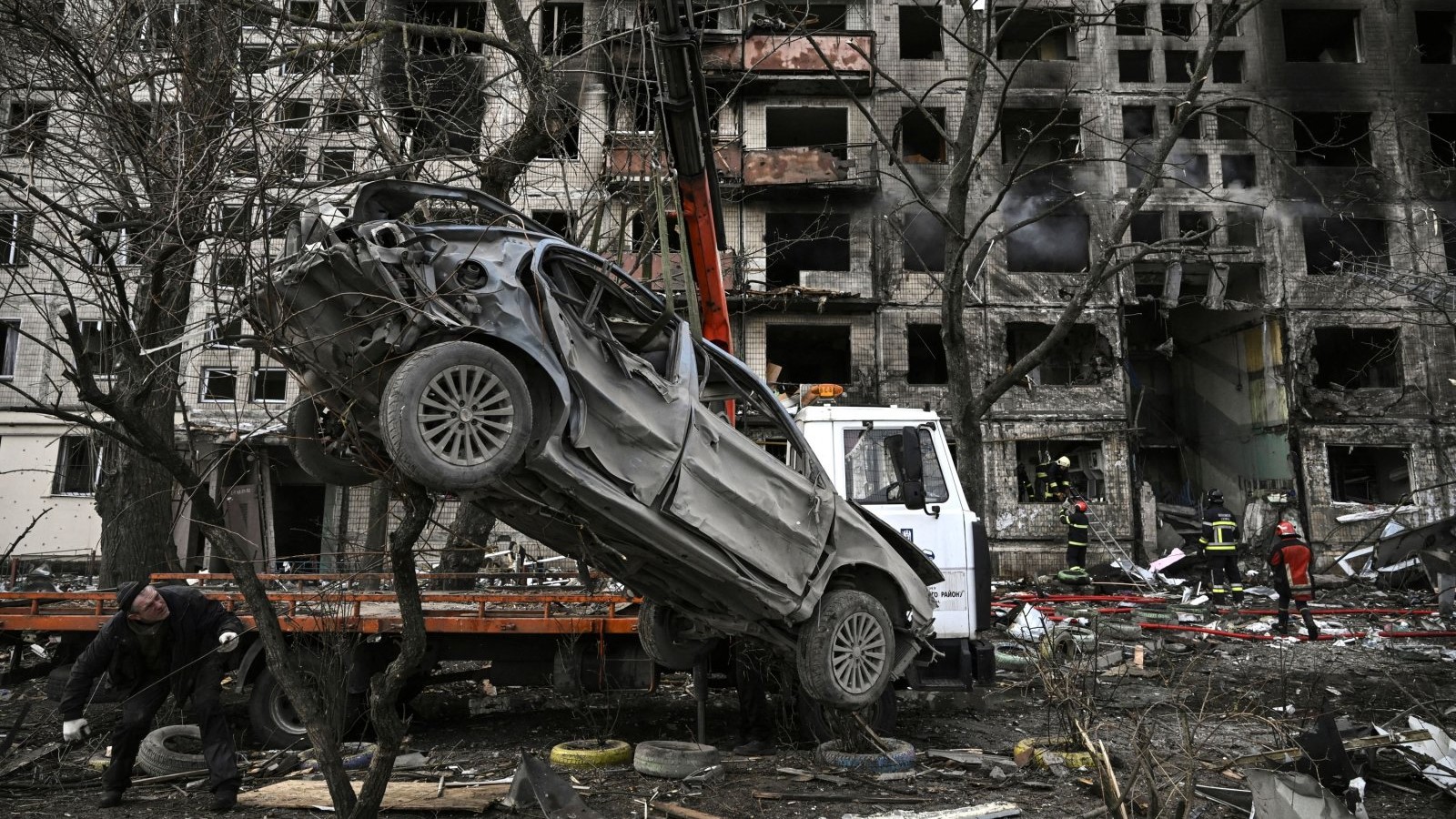 رافعة تزيل سيارة مدمرة من أمام مبنى سكني مدمر بعد أن قصفتها روسيا في كييف، أوكرانيا، في 14 مارس 2022