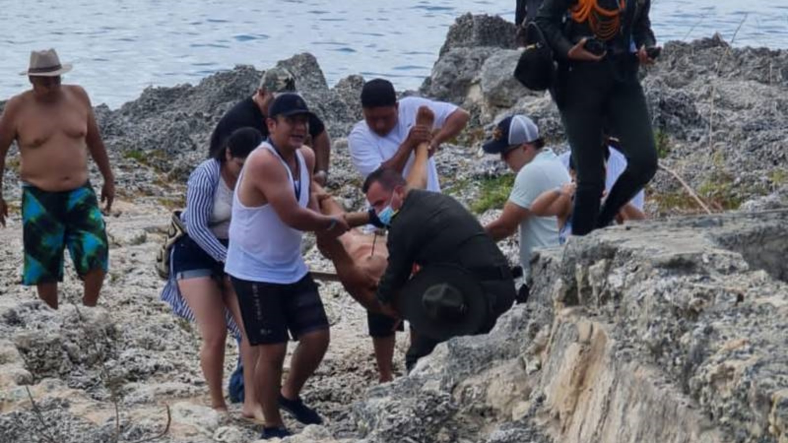 أشخاص يسحبون سائحًا من الشاطئ بعد أن هاجمته سمكة قرش.