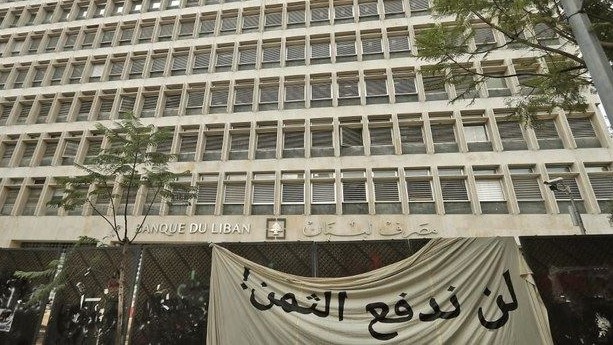 صورة من الأرشيف لمصرف لبنان المركزي وأمامه لافتة رفعها المودعون
