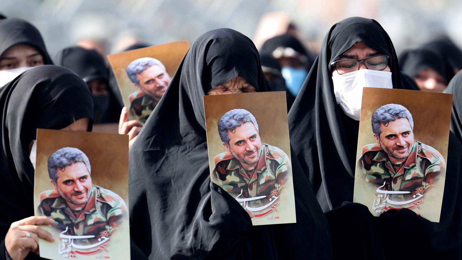 نساء إيرانيات يرفعن صور العقيد في الحرس الثوري حسن صياد خدائي خلال جنازته في ساحة الإمام الحسين، طهران، إيران، 24 أيار\مايو 2022