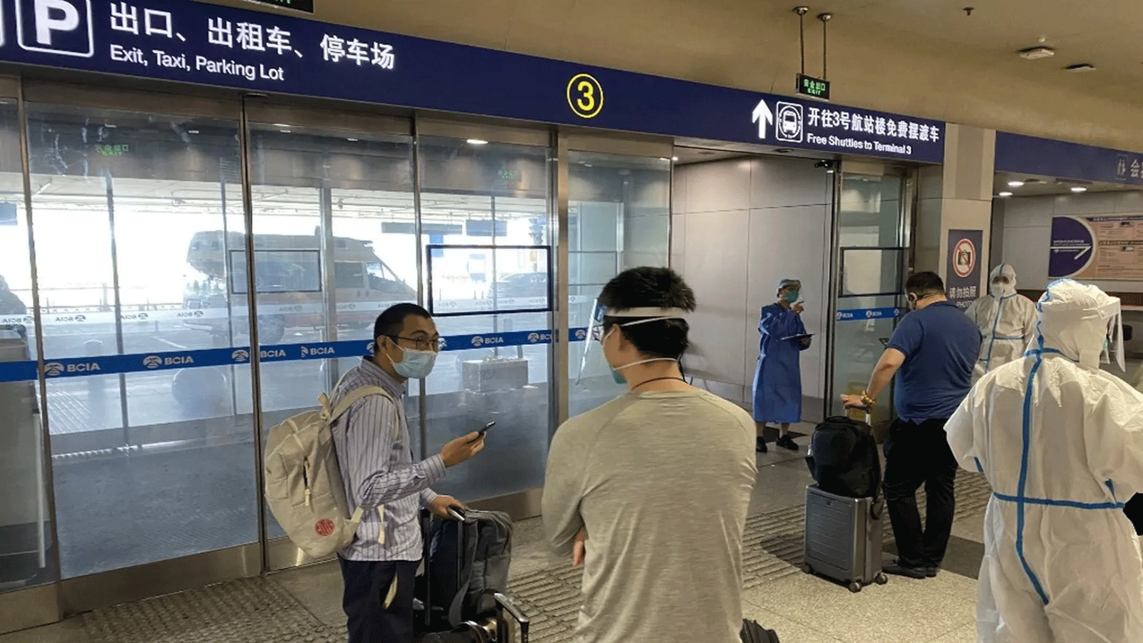 صورة تم التقاطها في 18 حزيران\ يونيو 2022 تُظهِر الركاب القادمين في انتظار نقلهم إلى وجهات مخصصة للحجر الصحي من مطار بكين الدولي في بكين.