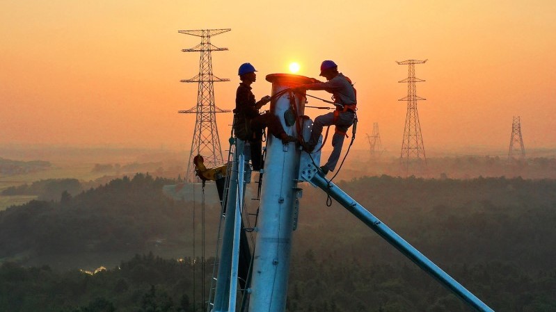 موظفون يعملون في برج نقل للتوتر العالي في ييتشون بمقاطعة جيانغشي بوسط الصين