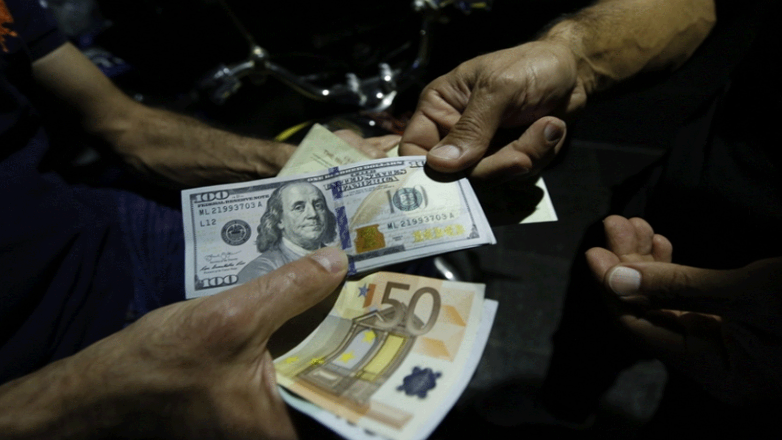 صراف يبادل اليورو بالدولار