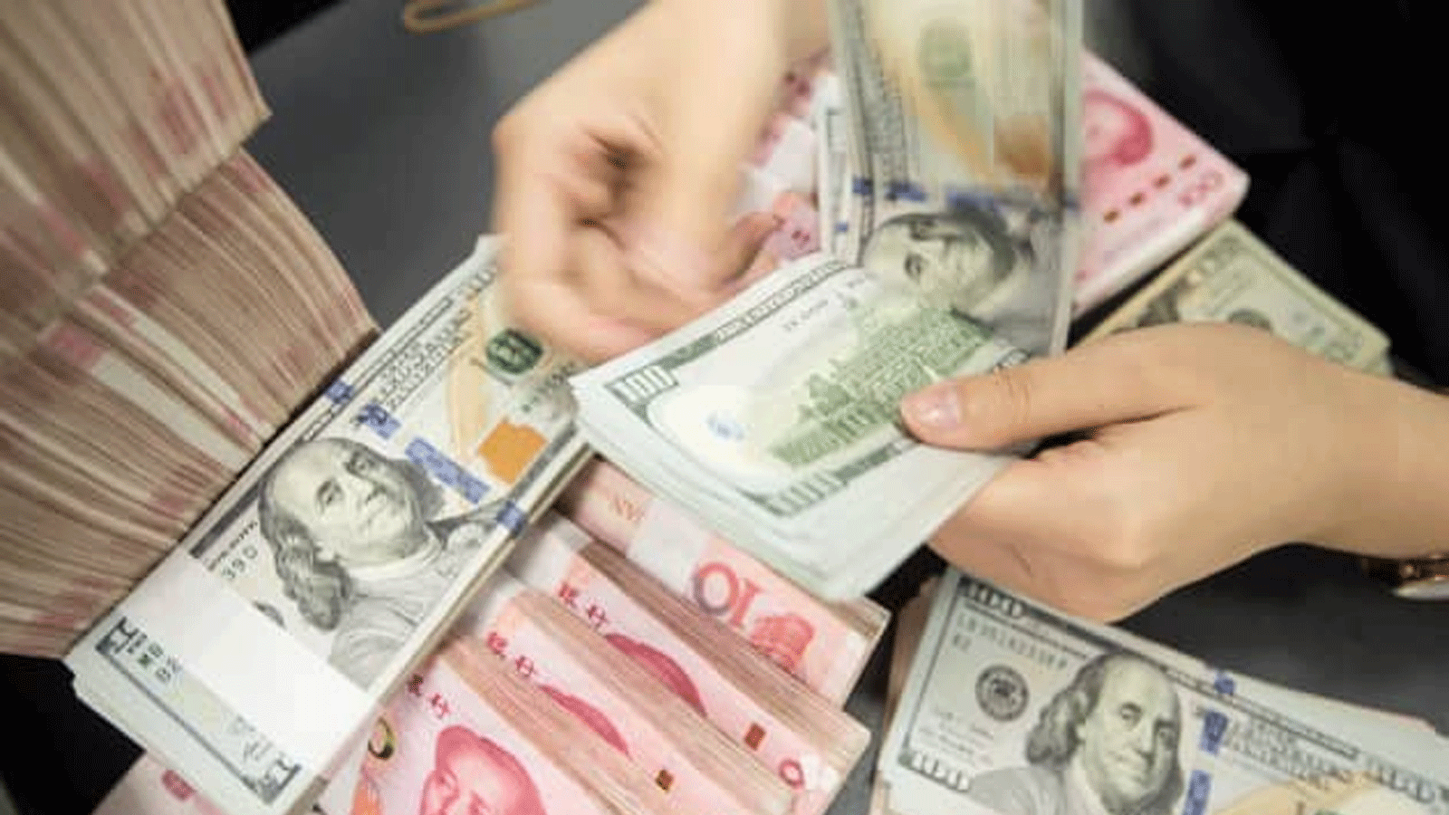 صرّاف يقوم بتحويل العملات بين اليورو والدولار