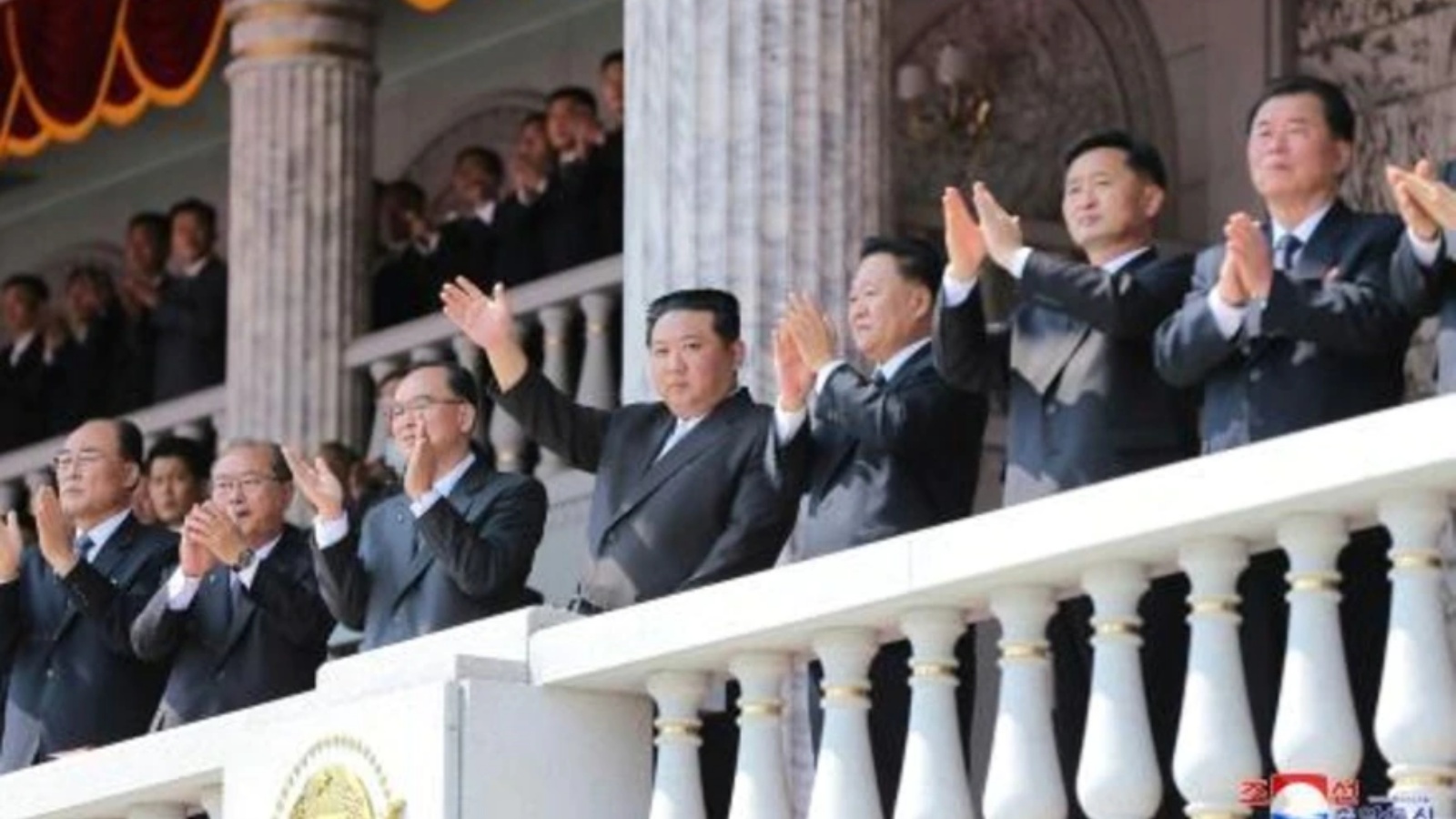 الزعيم الكوري الشمالي كيم جونغ أون يلوح من الشرفة للحشود في ساحة كيم إيل سونغ في بيونغ يانغ في 15 أبريل 2021 بمناسبة مرور 110 أعوام على مؤسس البلاد بمناسبة الذكرى الـ 110 لميلاد كيم إيل سونغ، جده والزعيم المؤسس البلا
