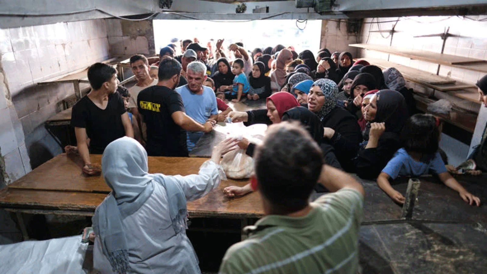 تتشكل طوابير طويلة خارج مخبز في مدينة طرابلس الساحلية بشمال لبنان حيث يضطر الناس أحيانًا إلى الانتظار لساعات للحصول على كيس من خبز البيتا العربي المدعوم