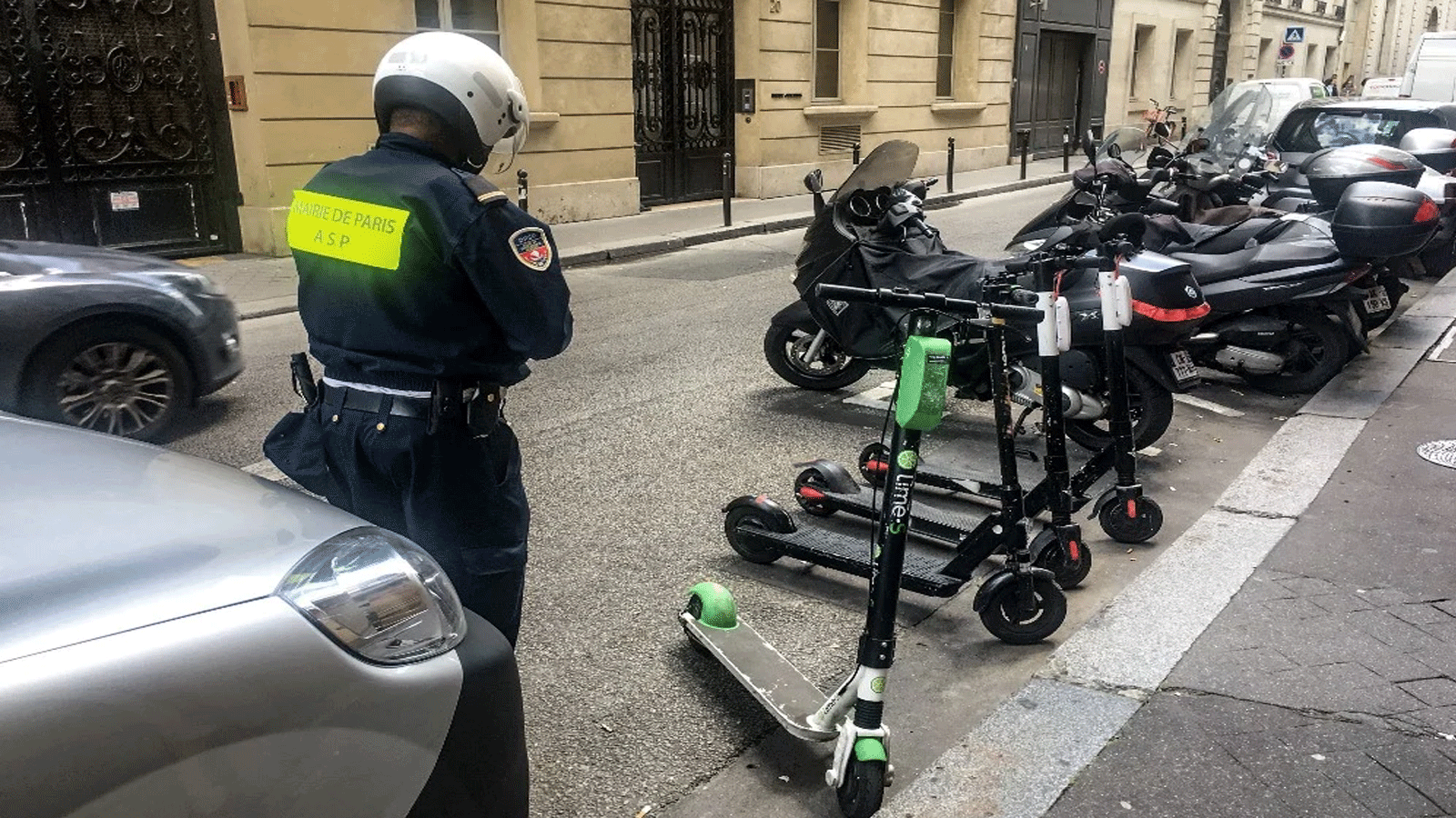 شرطي يراقب المركبات بعجلتين في باريس، حيث تم بدأ تطبيق دفع الرسوم لركنها