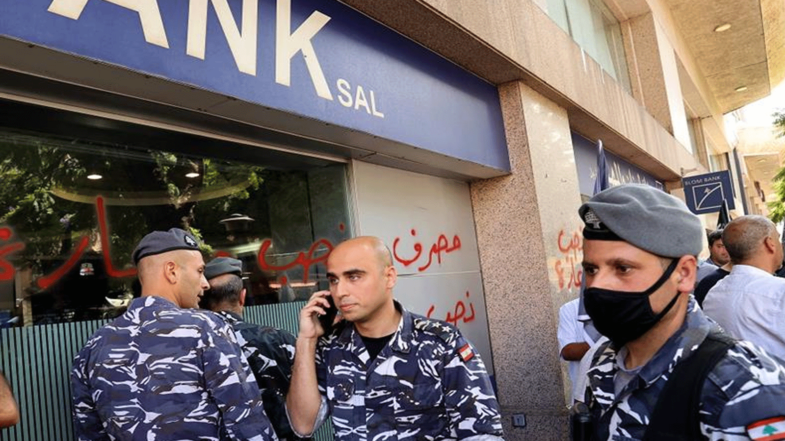أفراد من قوات الأمن اللبنانية يتجمعون أمام أحد البنوك في العاصمة اللبنانية بيروت، بعد أن اقتحمت امرأة مصرفاً للحصول على ودائع شقيقتها لدفع رسوم المستشفى. 14 أيلول\سبتمبر 2022. 