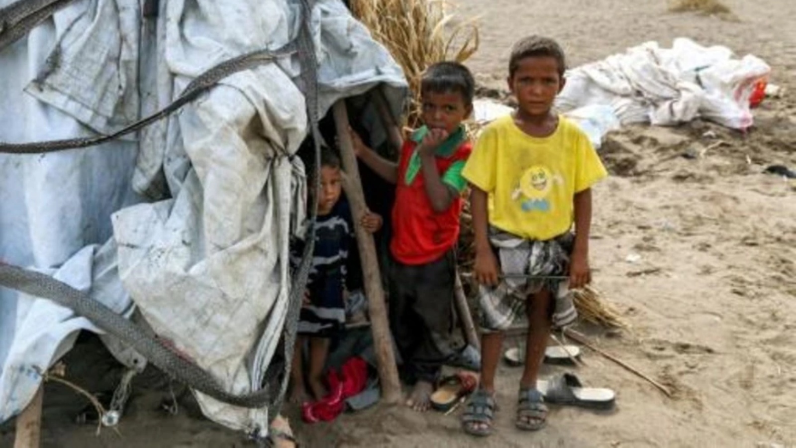  صورة التُقطت في 19 أغسطس لأطفال يقفون خارج خيمة في مخيم للنازحين تضرر من السيول في منطقة الجراحي التي دمرتها الحرب بمحافظة الحديدة غرب اليمن